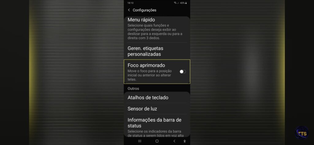 Descrição da imagem: Tela de “Configurações” de um celular Android (modo escuro), na seção “Menu rápido”. Aparece um texto explicando que você pode selecionar funções e configurações para exibir ao deslizar para a esquerda ou direita com 3 dedos. Abaixo, há itens como “Geren. etiquetas personalizadas” e “Foco aprimorado” (destacado com uma borda amarela), com a descrição “Move o foco para a posição inicial ou anterior ao alterar telas.” À direita desse item há um botão de alternância que parece estar desligado (cinza). Mais abaixo, na seção “Outros”, aparecem “Atalhos de teclado”, “Sensor de luz” e “Informações da barra de status”. No topo, a barra mostra 18:10 e bateria em 43%. Fim da descrição. 